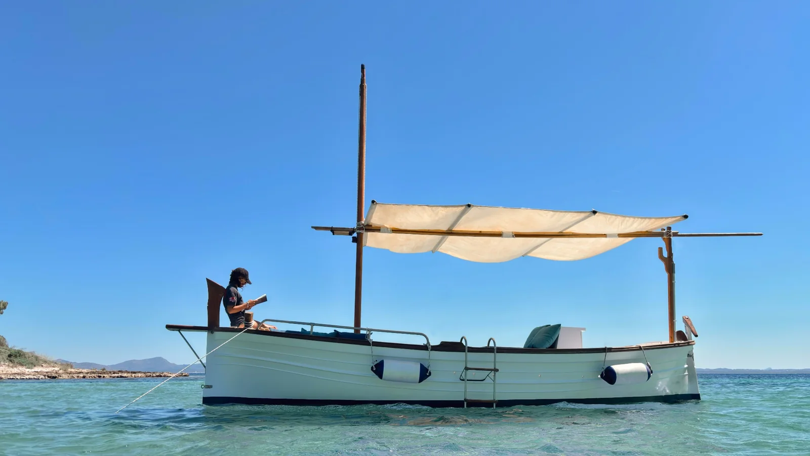 Barco tradicional con toldo sobre aguas transparentes
